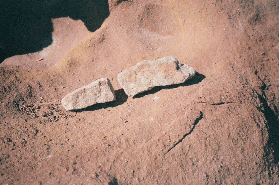 Two pale stones resting on Martian-red soil