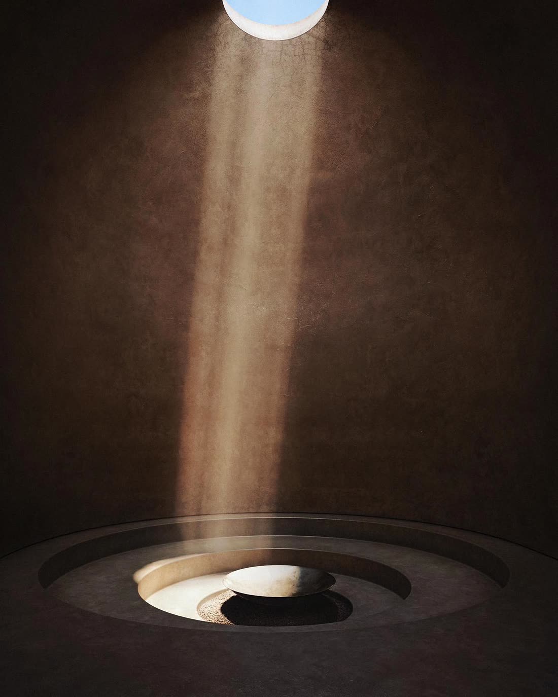 The Sound Dome — a shaft of light falls through an oculus onto a pale stone basin set in concentric rings of earthen plaster